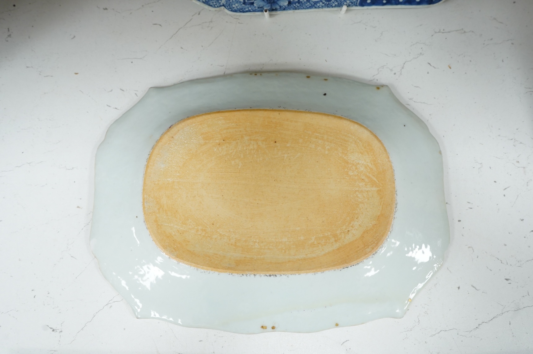 A late 18th century Chinese export blue and white serving dish and a similar famille rose serving platter, largest 37.5cm